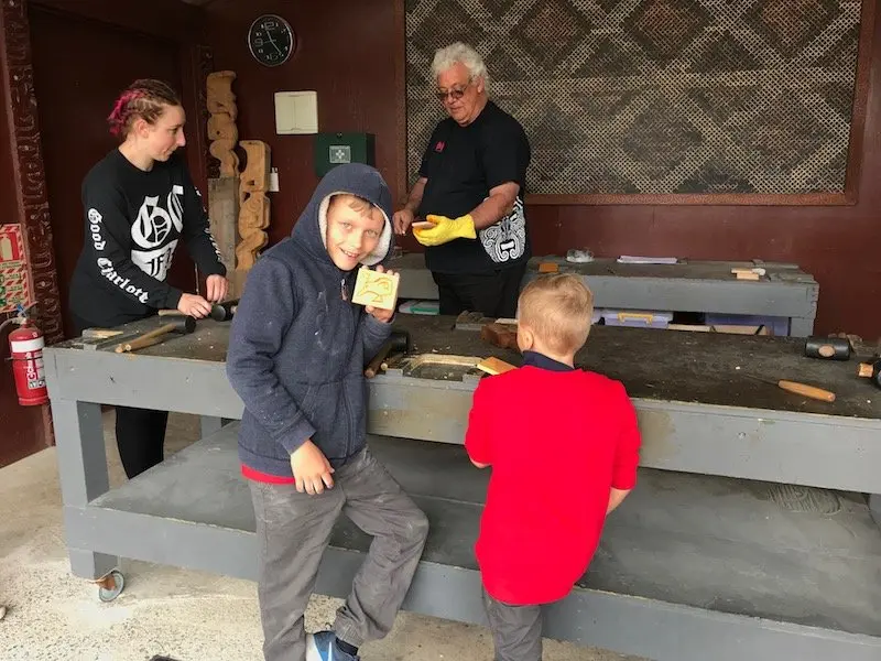 Photo- boys doing maori carving at hells gate thermal park