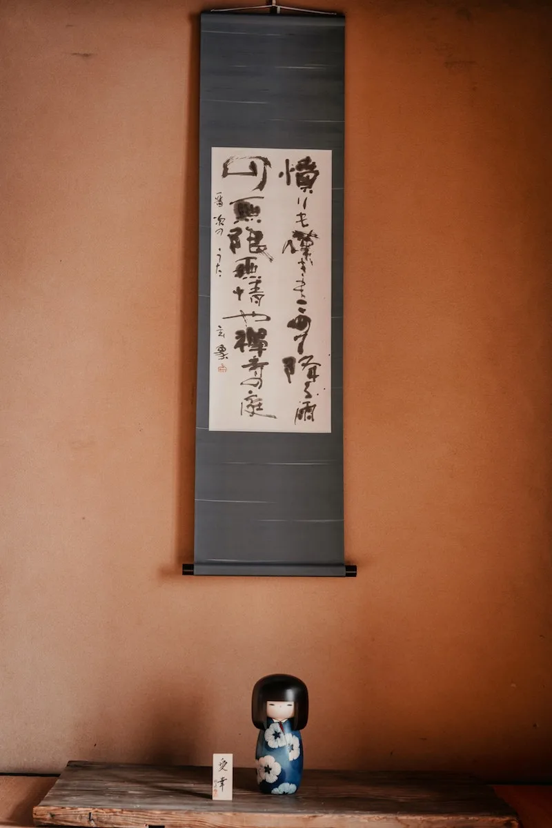 image - Japanese calligraphy art scroll and kokeshi doll by koto-kyoto unsplash
